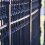 vertical-closeup-shot-metal-fence-sidewalk